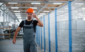 Going forward. Industrial worker indoors in factory. Young technician with orange hard hat photo