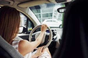 mujer conductora dentro de un automóvil moderno. probando auto nuevo foto