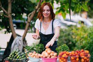 mujer vendedora en el mostrador con verduras. concepto de pequeña empresa foto