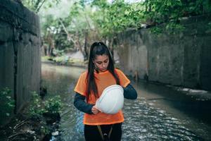 Young beautiful woman digger walks along the rain collector photo