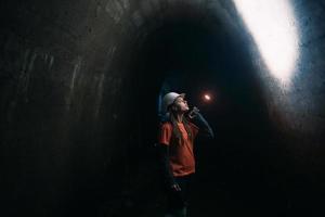 mujer excavadora con linterna explora el túnel foto