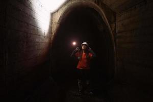 mujer excavadora con linterna explora el túnel foto