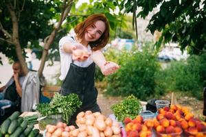 mujer vendedora en el mostrador con verduras. concepto de pequeña empresa foto