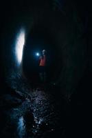 mujer excavadora con linterna explora el túnel foto