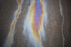 Gasoline stain on asphalt. Spilled fuel. photo