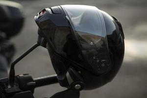 casco de motociclista. casco negro en motocicleta. herramienta de seguridad foto