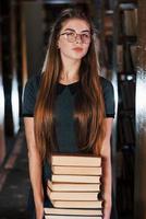 hay mucha información en esos libros que en las manos. estudiante femenina está en la biblioteca. concepción de la educación foto