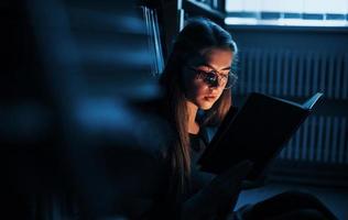 cada día más inteligente. una estudiante está en una biblioteca llena de libros. concepción de la educación foto