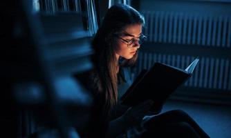 cada día más inteligente. una estudiante está en una biblioteca llena de libros. concepción de la educación foto