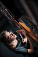 Aerial view. Female student is in library that full of books. Conception of education photo