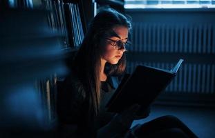 Getting smarter every day. Female student is in library that full of books. Conception of education photo