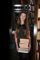 hay mucha información en esos libros que en las manos. estudiante femenina está en la biblioteca. concepción de la educación foto