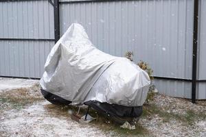 Motorcycle storage under an awning in winter outdoor. Protective awning, under the snow photo