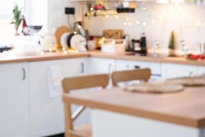 Interior background in a blur of white wooden kitchen of Festive Christmas decor and mess, festive breakfast, white scandi interior. New Year, mood, cozy home photo