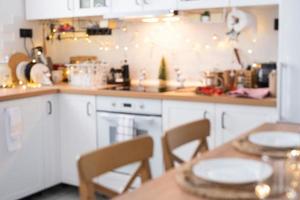 Interior background in a blur of white wooden kitchen of Festive Christmas decor and mess, festive breakfast, white scandi interior. New Year, mood, cozy home photo