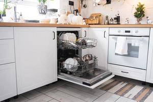 A lot of dirty dishes in the dishwasher. Helping the hostess, economy and ecology. Cleaning in the kitchen for the holidays of Christmas and New Year, after the feast and guests photo