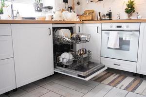 A lot of dirty dishes in the dishwasher. Helping the hostess, economy and ecology. Cleaning in the kitchen for the holidays of Christmas and New Year, after the feast and guests photo