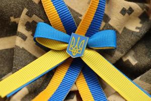 Military camouflage fabric with ukrainian stripes on ribbon photo