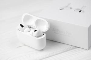 KHARKIV, UKRAINE - JANUARY 27, 2022 Apple AirPods Pro on a white background. Wireless headphones with charging case and a box. Apple Inc. is an American technology company photo