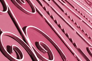 Metal texture of a piece of wall with a forged pattern Image toned in Viva Magenta, color of the 2023 year photo