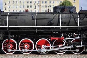 Red wheels of steam train photo