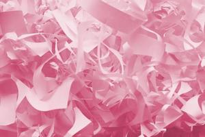 Shredded paper texture background, top view of many white paper strips. Pile of cut paper like box filler for shipping fragile items Image toned in Viva Magenta, color of the 2023 year photo