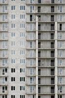 patrón texturizado de una pared de construcción de casas residenciales de piedra blanca rusa con muchas ventanas y balcón en construcción foto