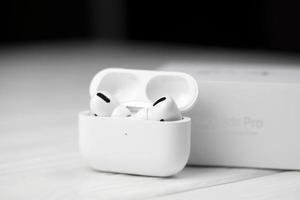 KHARKIV, UKRAINE - JANUARY 27, 2022 Apple AirPods Pro on a white background. Wireless headphones with charging case and a box. Apple Inc. is an American technology company photo