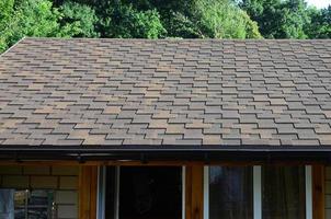 Modern roofing and decoration of chimneys. Flexible bitumen or slate shingles photo