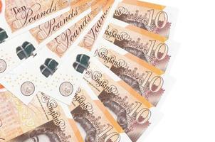 10 British pounds bills lies isolated on white background with copy space stacked in fan shape close up photo