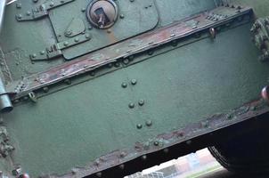 Texture of tank side wall, made of metal and reinforced with a multitude of bolts and rivets photo