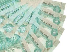 10 UAE dirhams bills lies isolated on white background with copy space stacked in fan shape close up photo