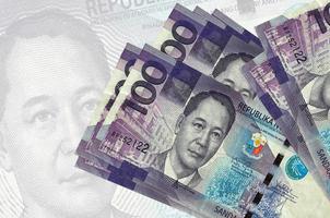 100 Philippine piso bills lies in stack on background of big semi-transparent banknote. Abstract presentation of national currency photo