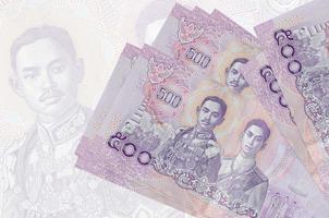 Los billetes de 500 baht tailandeses se encuentran apilados en el fondo de un gran billete semitransparente. presentación abstracta de la moneda nacional foto