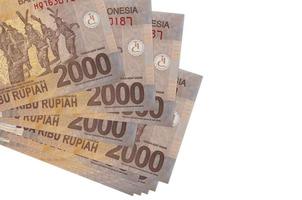 Los billetes de 2000 rupias indonesias se encuentran en un pequeño grupo o en un paquete aislado en blanco. maqueta con espacio de copia. negocios y cambio de moneda foto