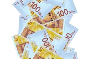 100 Israeli new shekels bills flying down isolated on white. Many banknotes falling with white copyspace on left and right side photo