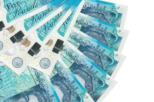 5 British pounds bills lies isolated on white background with copy space stacked in fan shape close up photo