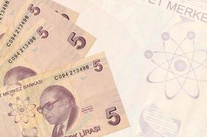5 billetes de liras turcas se encuentran apilados en el fondo de un gran billete semitransparente. fondo de negocios abstracto foto