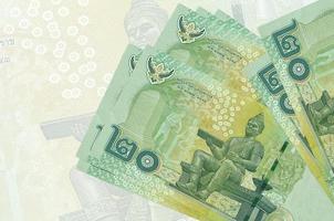 Los billetes de 20 baht tailandeses se encuentran apilados en el fondo de un gran billete semitransparente. presentación abstracta de la moneda nacional foto