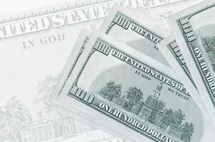 Los billetes de 100 dólares estadounidenses se encuentran apilados en el fondo de un gran billete semitransparente. presentación abstracta de la moneda nacional