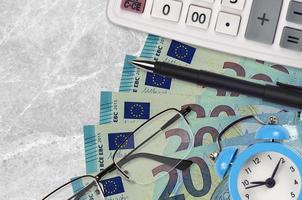 20 euro bills and calculator with glasses and pen. Business loan or tax payment season concept. Time to pay taxes photo