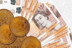 10 British pounds bills and golden bitcoins. Cryptocurrency investment concept. Crypto mining or trading photo