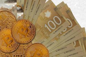 Billetes de 100 dólares canadienses y bitcoins dorados. concepto de inversión en criptomonedas. criptominería o comercio