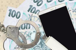 100 Czech korun bills and smartphone with police handcuffs. Concept of hackers phishing attacks, illegal scam or malware soft distribution photo