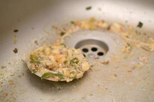 Close up on dirty clogging kitchen sink drain with food particles photo