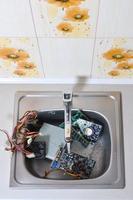 Hardware in kitchen sink under the water flow computer cleaning metaphoric concept photo