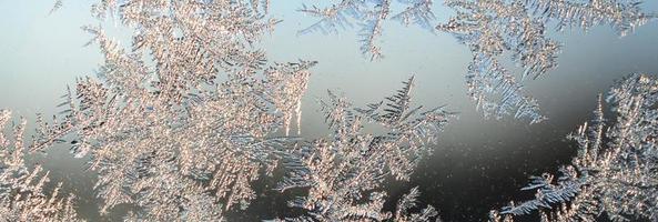 Snowflakes frost rime macro on window glass pane photo