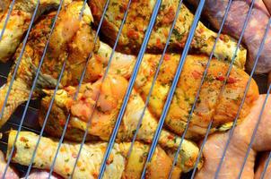 Marinated chicken legs on hot BBQ charcoal field grill photo