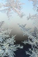 Snowflakes frost rime macro on window glass pane photo