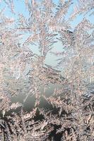 Snowflakes frost rime macro on window glass pane photo